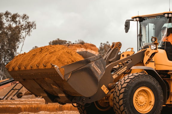 yellow and black heavy equipment on brown field during daytime